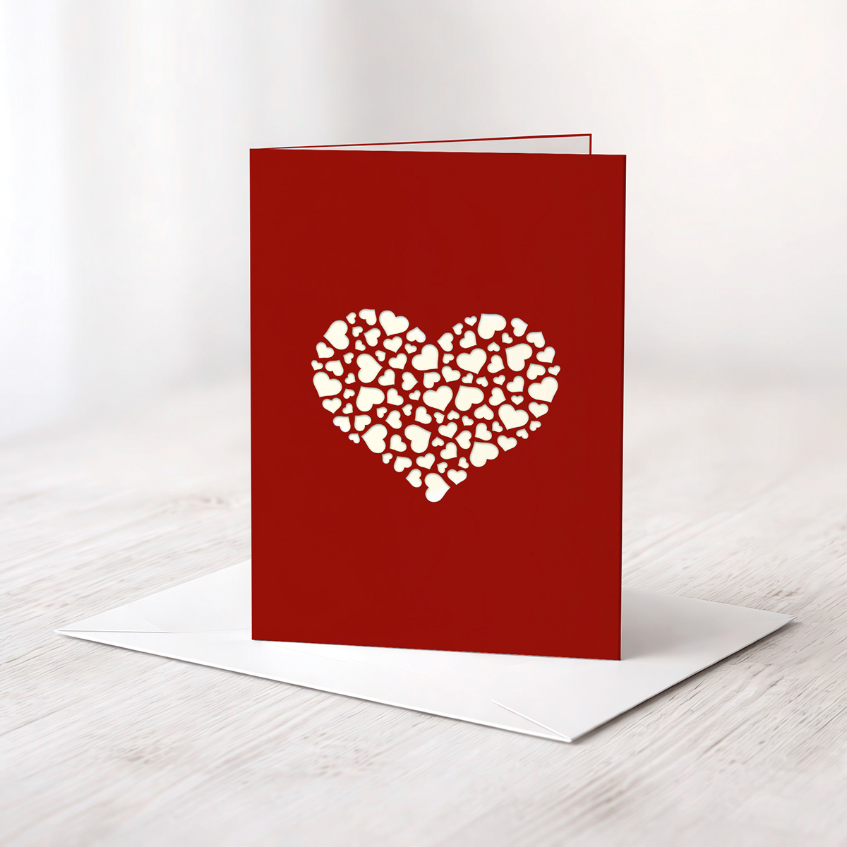 Rote Karte mit einem ausgelaserten Herz in der Mitte das wiederum aus vielen kleinen Herzen besteht.